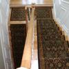 Stair runners flow to match landing rug and continue down.